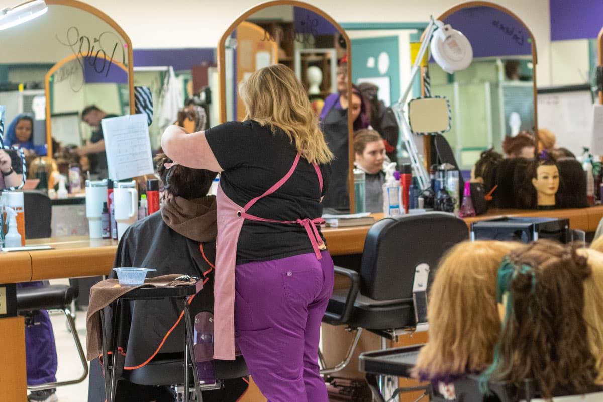 A San Juan College student giving a hair cut