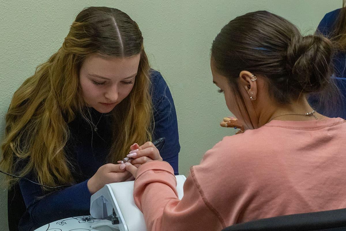 A San Juan College student giving a manicure